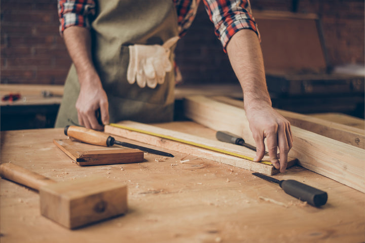 Amish woodworker measuring furniture