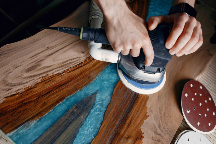 Amish craftsman sanding live edge table